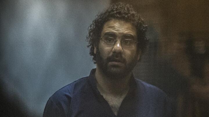 Activist and blogger Alaa Abdel Fattah sits in a cage at his trial with 25 other defendants in Cairo, Egypt, on May 23, 2015.